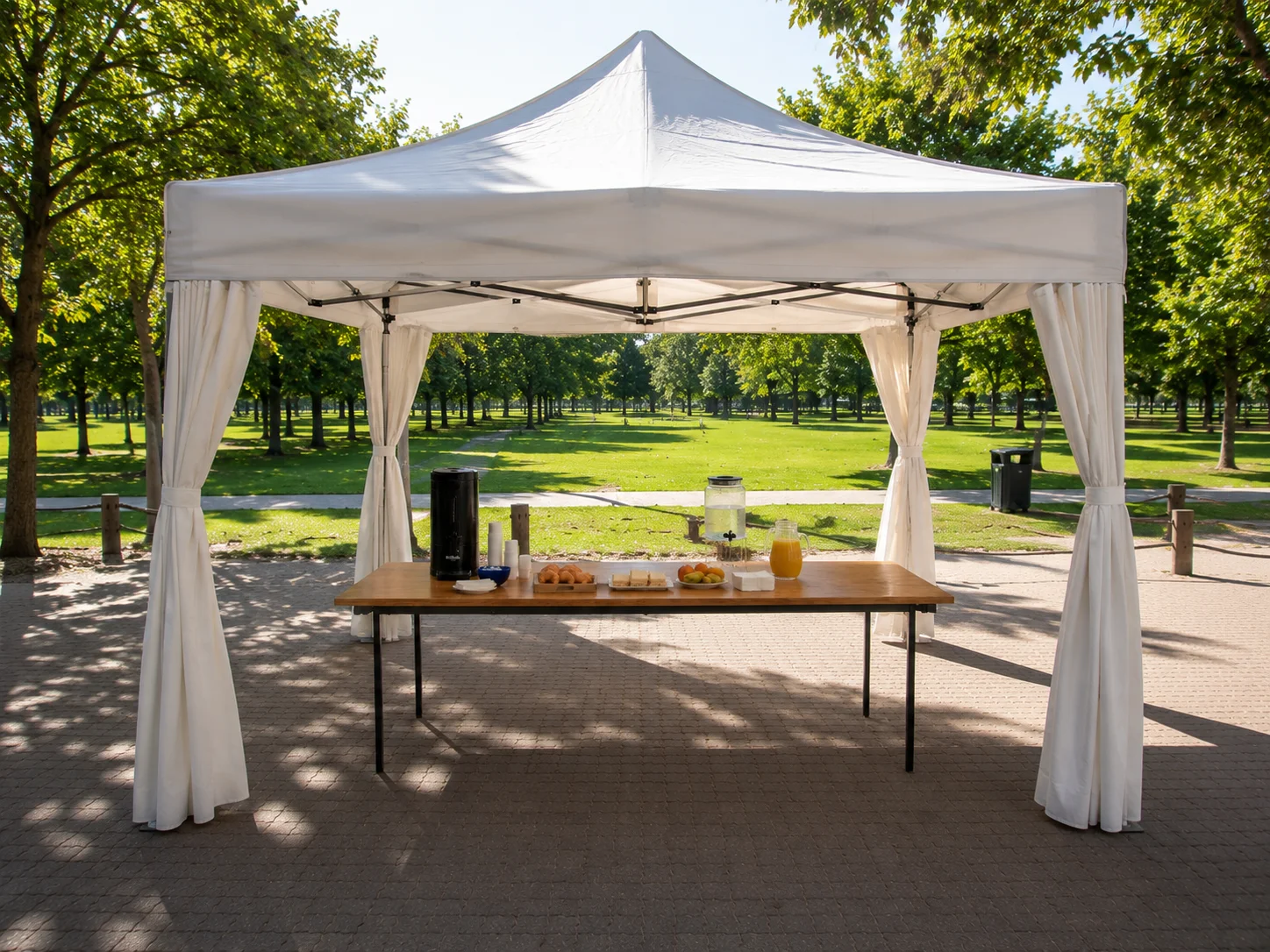 Gazebo blanco en parque con estación de catering itinerante